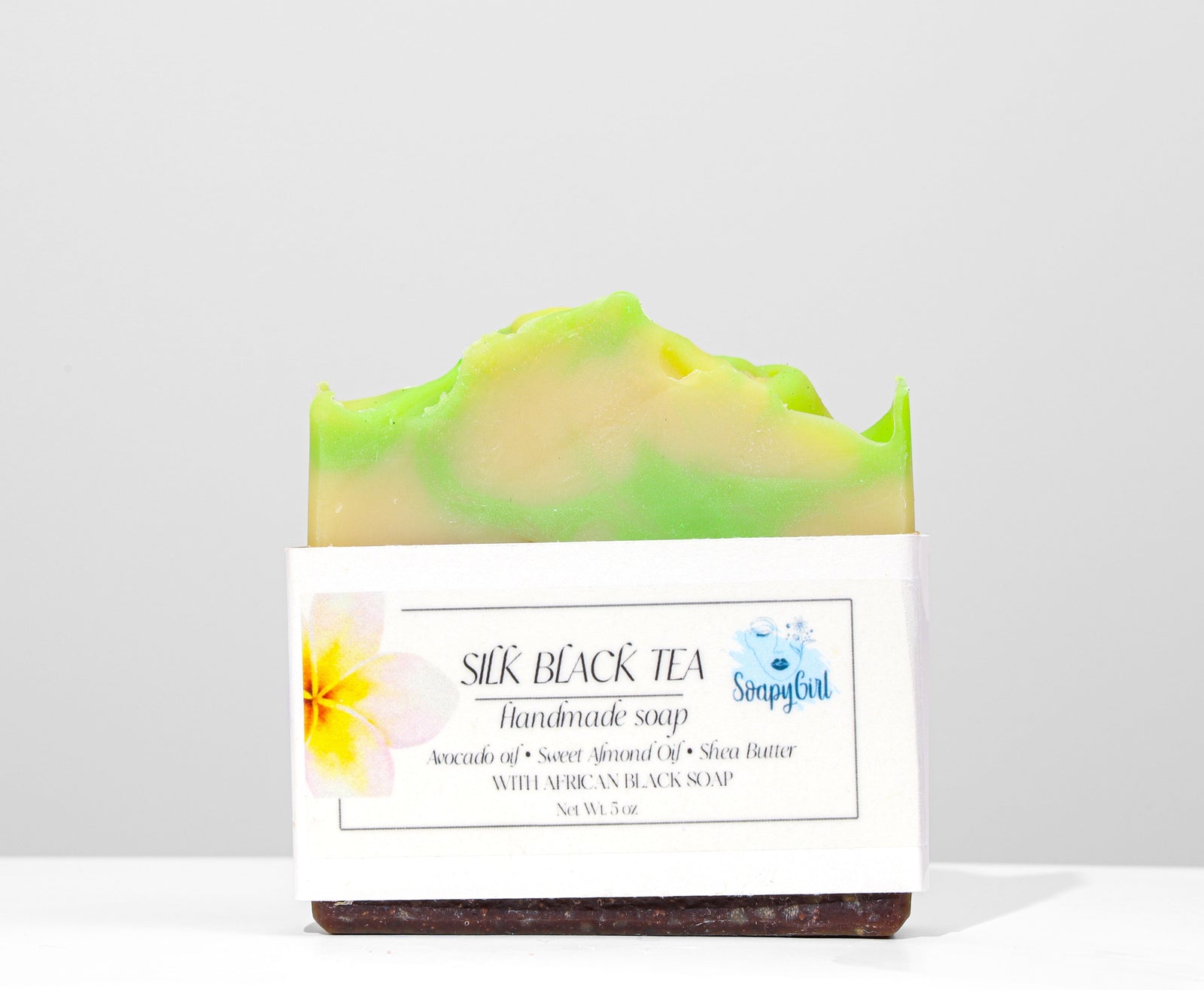 Handmade soap bar with green and yellow swirls on a white background